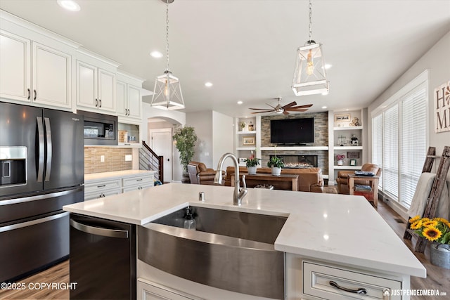 5167 E Henhouse Loop, Wasilla, AK 99654 - kitchen featuring fridge with ice dispenser, a sink, a large fireplace, open floor plan, and a ceiling fan