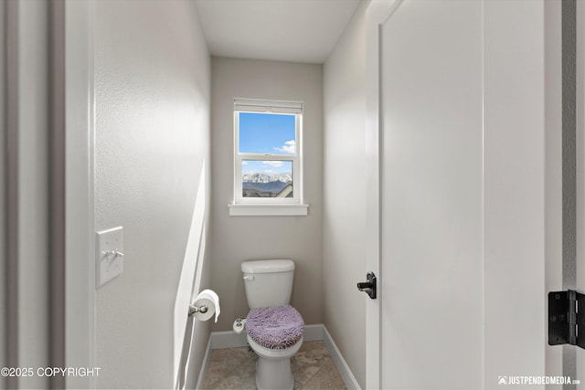 5167 E Henhouse Loop, Wasilla, AK 99654 - bathroom featuring toilet, baseboards, and tile patterned floors