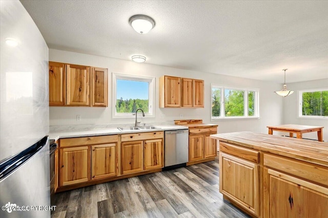 14045 W Willow Fishhook Rd, Willow, AK 99688 - kitchen with appliances with stainless steel finishes, a sink, dark wood-style floors, a textured ceiling, and hanging light fixtures