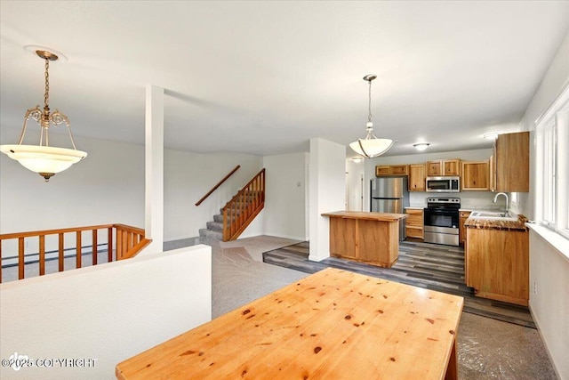 14045 W Willow Fishhook Rd, Willow, AK 99688 - kitchen featuring appliances with stainless steel finishes, brown cabinets, open floor plan, a sink, and hanging light fixtures