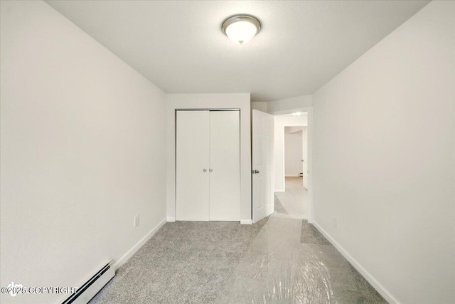 14045 W Willow Fishhook Rd, Willow, AK 99688 - unfurnished bedroom with carpet, a baseboard radiator, baseboards, and a closet