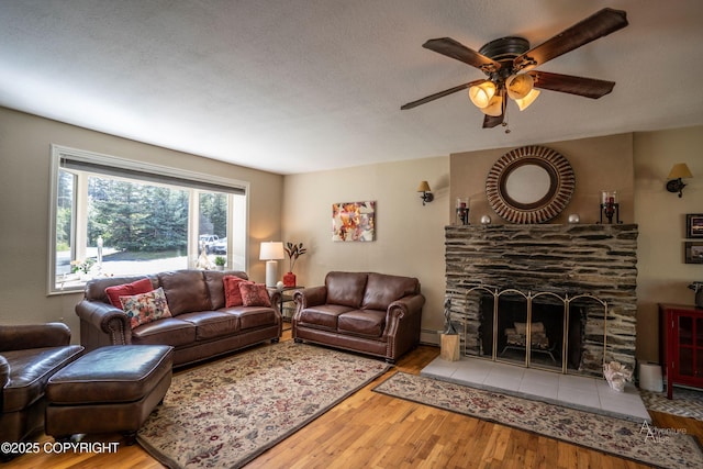 2503 Cedar St, Seward, AK 99664 - living area with wood finished floors, ceiling fan, baseboard heating, and a stone fireplace