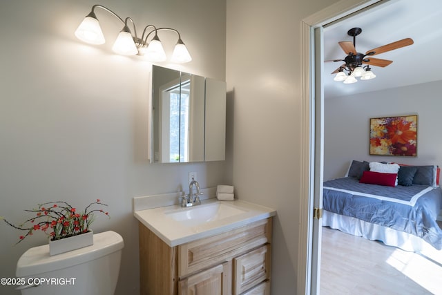 2503 Cedar St, Seward, AK 99664 - bathroom with vanity, toilet, a ceiling fan, and wood finished floors