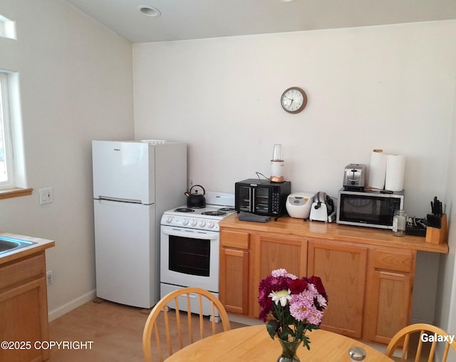 2503 Cedar St, Seward, AK 99664 - kitchen featuring white appliances, light wood-type flooring, a sink, and baseboards