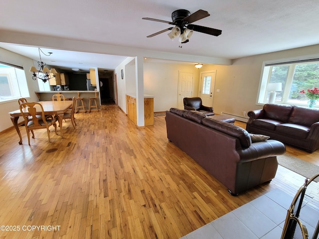 2503 Cedar St, Seward, AK 99664 - living room with light wood-style floors, a baseboard heating unit, ceiling fan, and a chandelier