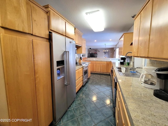 2503 Cedar St, Seward, AK 99664 - kitchen featuring appliances with stainless steel finishes, light countertops, dark tile patterned floors, light brown cabinets, and pendant lighting