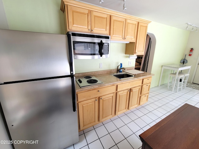 2503 Cedar St, Seward, AK 99664 - kitchen featuring appliances with stainless steel finishes, rail lighting, light brown cabinets, arched walkways, and light tile patterned floors