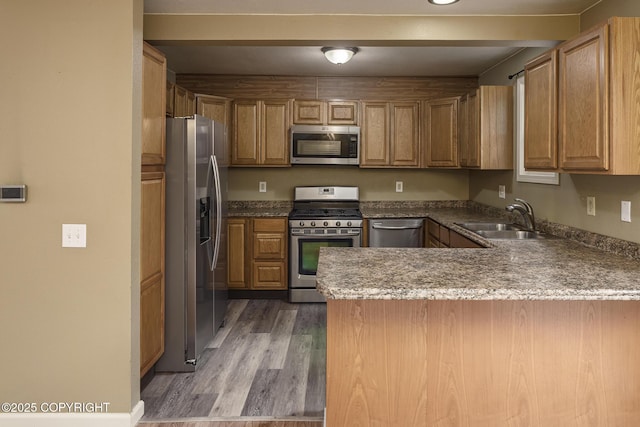 4012 Reka Dr # G5, Anchorage, AK 99508 - kitchen featuring stainless steel appliances, a sink, a peninsula, light wood-type flooring, and stone countertops