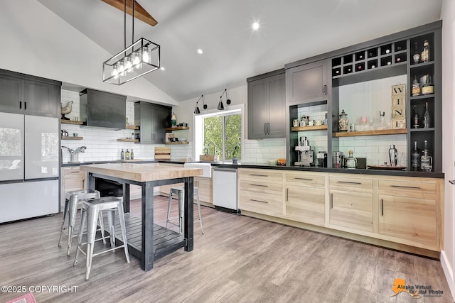 16111 E Nosey Ave, Talkeetna, AK 99676 - kitchen featuring open shelves, freestanding refrigerator, dark countertops, lofted ceiling, and custom range hood