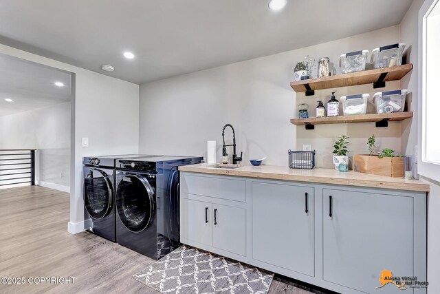 16111 E Nosey Ave, Talkeetna, AK 99676 - laundry room with washer and clothes dryer, cabinet space, light wood-style flooring, recessed lighting, and baseboards