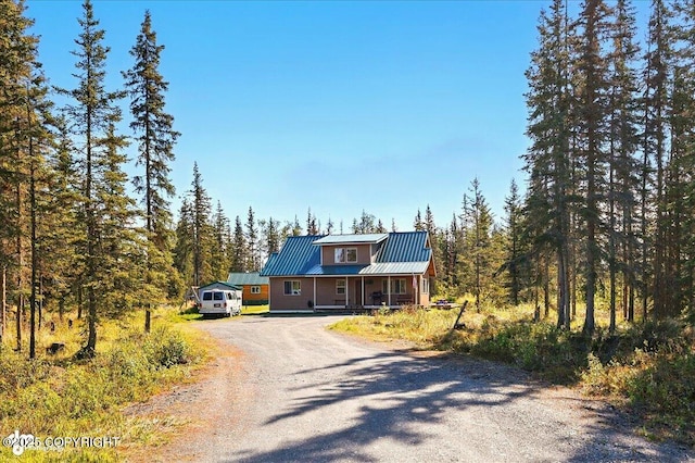 34540 Poppy Wood St, Soldotna, AK 99669 - view of front of home with dirt driveway, a metal roof, and a forest view