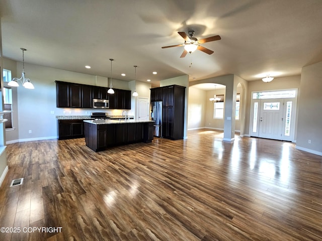 5523 Grand Teton Loop, Anchorage, AK 99502 - kitchen with appliances with stainless steel finishes, open floor plan, a sink, arched walkways, and baseboards