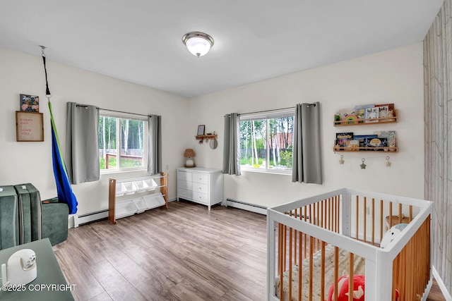 4850 N Riverstone Cir, Palmer, AK 99645 - bedroom with multiple windows, wood finished floors, a nursery area, and a baseboard radiator