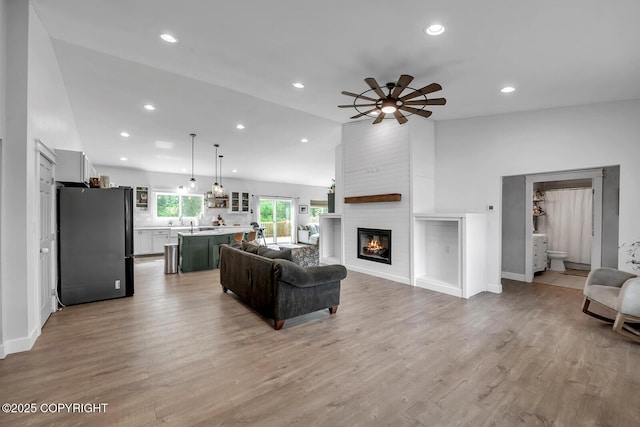 4850 N Riverstone Cir, Palmer, AK 99645 - living area featuring recessed lighting, ceiling fan, a fireplace, light wood-style flooring, and vaulted ceiling