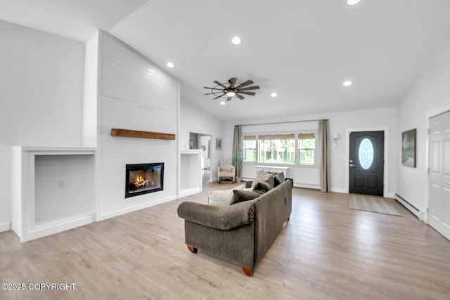 4850 N Riverstone Cir, Palmer, AK 99645 - living room with vaulted ceiling, baseboard heating, ceiling fan, a fireplace, and light wood-type flooring
