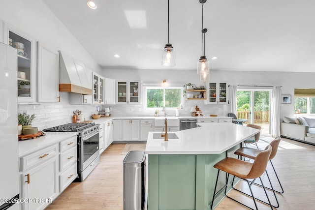 4850 N Riverstone Cir, Palmer, AK 99645 - kitchen with appliances with stainless steel finishes, premium range hood, a kitchen island with sink, tasteful backsplash, and a kitchen breakfast bar