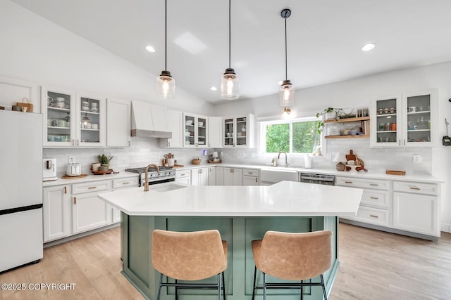 4850 N Riverstone Cir, Palmer, AK 99645 - kitchen with freestanding refrigerator, custom exhaust hood, backsplash, a kitchen island with sink, and a sink