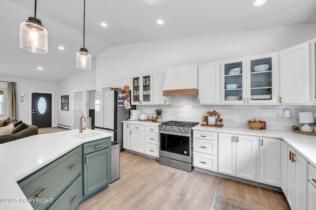 4850 N Riverstone Cir, Palmer, AK 99645 - kitchen featuring stainless steel range with gas cooktop, premium range hood, a sink, freestanding refrigerator, and lofted ceiling