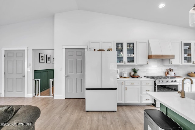 4850 N Riverstone Cir, Palmer, AK 99645 - kitchen featuring freestanding refrigerator, premium range hood, white cabinets, stainless steel range with gas stovetop, and light countertops
