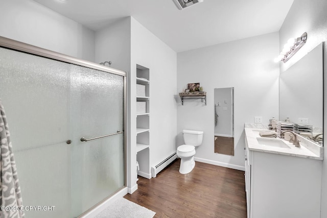 4850 N Riverstone Cir, Palmer, AK 99645 - bathroom with baseboard heating, toilet, a shower stall, wood finished floors, and double vanity