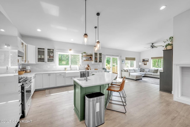 4850 N Riverstone Cir, Palmer, AK 99645 - kitchen with stainless steel gas range oven, plenty of natural light, a kitchen island with sink, light wood finished floors, and recessed lighting