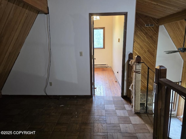 5650 N Talgach View Dr, Wasilla, AK 99654 - hallway with a baseboard heating unit, beam ceiling, an upstairs landing, and wooden walls