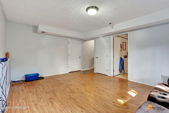 3040 Rosalind Loop, Anchorage, AK 99507 - unfurnished living room featuring a textured ceiling, wood finished floors, stairway, and baseboards
