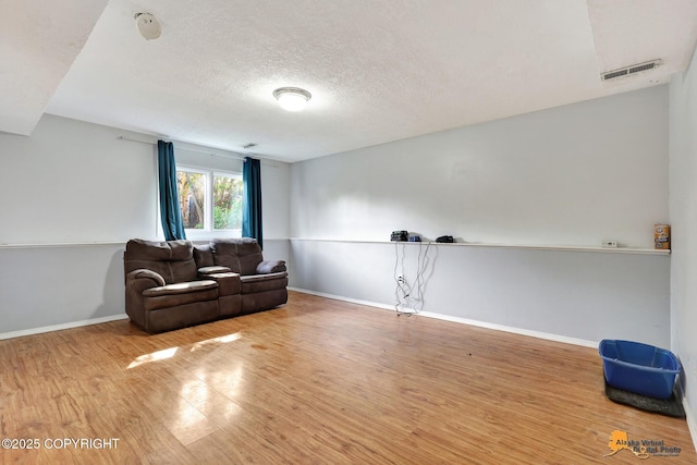 3040 Rosalind Loop, Anchorage, AK 99507 - sitting room featuring wood finished floors, baseboards, and a textured ceiling