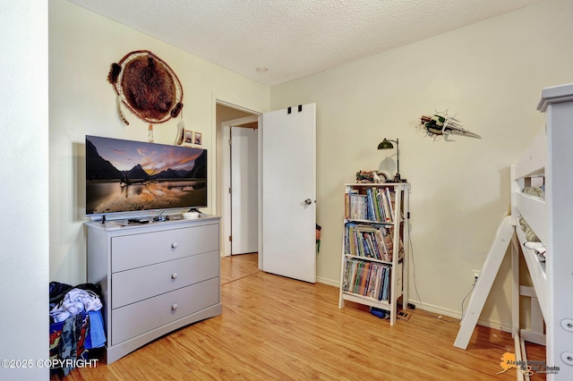 3040 Rosalind Loop, Anchorage, AK 99507 - bedroom featuring wood finished floors, a textured ceiling, and baseboards