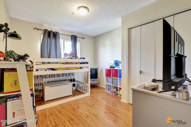 3040 Rosalind Loop, Anchorage, AK 99507 - bedroom with wood finished floors, a textured ceiling, and a closet