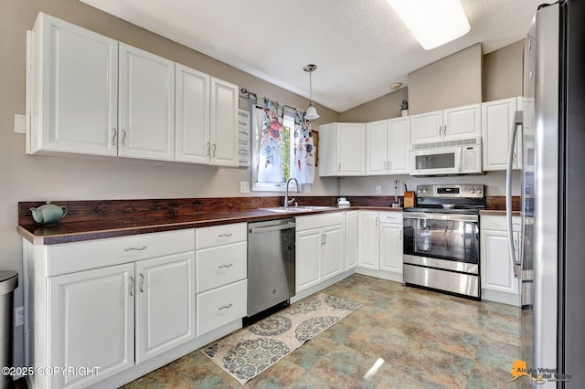 3040 Rosalind Loop, Anchorage, AK 99507 - kitchen featuring stainless steel appliances, a sink, lofted ceiling, white cabinets, and a textured ceiling