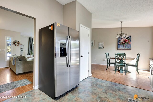 3040 Rosalind Loop, Anchorage, AK 99507 - kitchen featuring stainless steel fridge, wood finished floors, a chandelier, baseboards, and hanging light fixtures