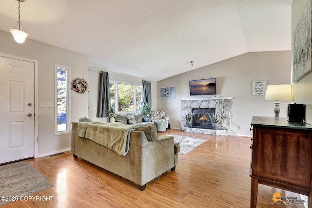 3040 Rosalind Loop, Anchorage, AK 99507 - living area with lofted ceiling, light wood-type flooring, a fireplace, and baseboards