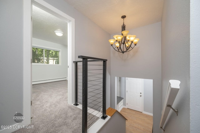 13311 Cove Cir, Anchorage, AK 99515 - hall featuring a baseboard heating unit, a chandelier, and an upstairs landing