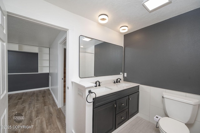 13311 Cove Cir, Anchorage, AK 99515 - full bathroom with double vanity, wood finished floors, and a textured ceiling