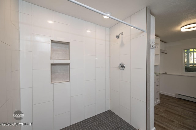 13311 Cove Cir, Anchorage, AK 99515 - full bathroom with a tile shower, a baseboard heating unit, wood finished floors, and a textured ceiling