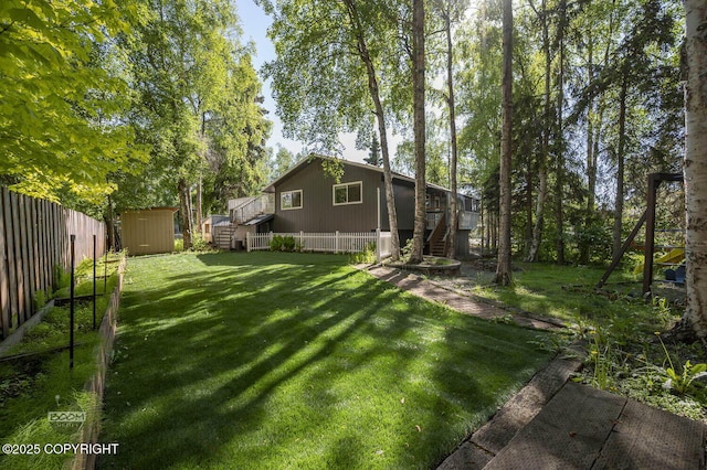 13311 Cove Cir, Anchorage, AK 99515 - fenced backyard with stairs, a storage shed, and a wooden deck