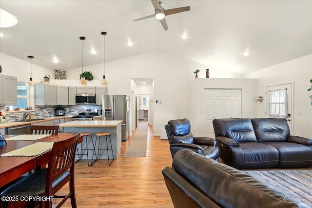 47974 Barney Ct, Soldotna, AK 99669 - living room featuring vaulted ceiling, a ceiling fan, healthy amount of natural light, light wood-type flooring, and recessed lighting