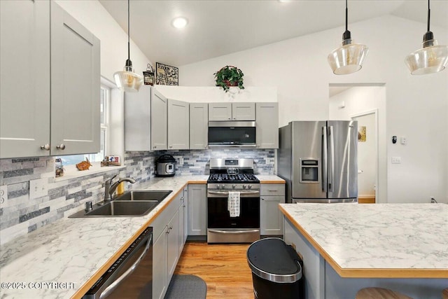 47974 Barney Ct, Soldotna, AK 99669 - kitchen with appliances with stainless steel finishes, a sink, vaulted ceiling, decorative backsplash, and gray cabinets