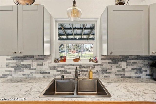 47974 Barney Ct, Soldotna, AK 99669 - kitchen featuring a sink, decorative backsplash, light stone counters, and decorative light fixtures