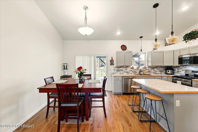 47974 Barney Ct, Soldotna, AK 99669 - dining area featuring light wood finished floors, lofted ceiling, and baseboards