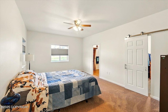 47974 Barney Ct, Soldotna, AK 99669 - carpeted bedroom with a barn door, baseboards, and ceiling fan