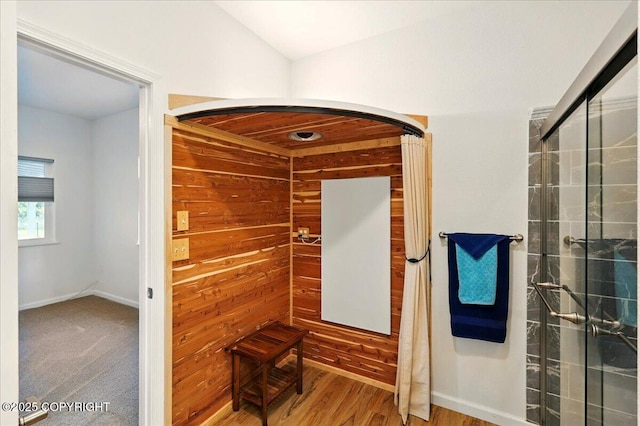 47974 Barney Ct, Soldotna, AK 99669 - hallway featuring wooden walls, baseboards, arched walkways, and wood finished floors