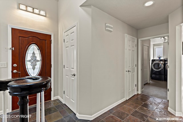 18704 Snowy Plover Cir, Anchorage, AK 99516 - entryway featuring independent washer and dryer, stone tile flooring, and baseboards