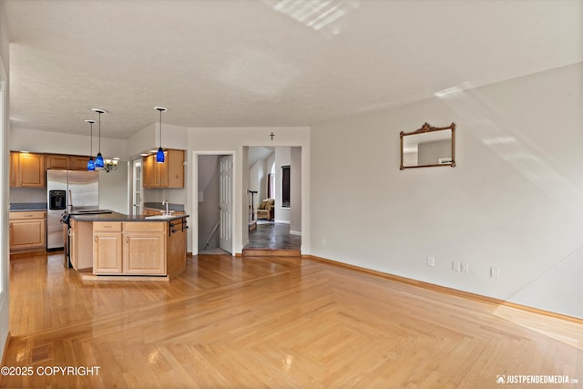 18704 Snowy Plover Cir, Anchorage, AK 99516 - kitchen featuring stainless steel fridge, dark countertops, baseboards, and pendant lighting