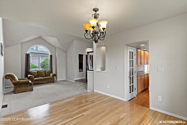 18704 Snowy Plover Cir, Anchorage, AK 99516 - unfurnished living room featuring a chandelier, light wood finished floors, and baseboards