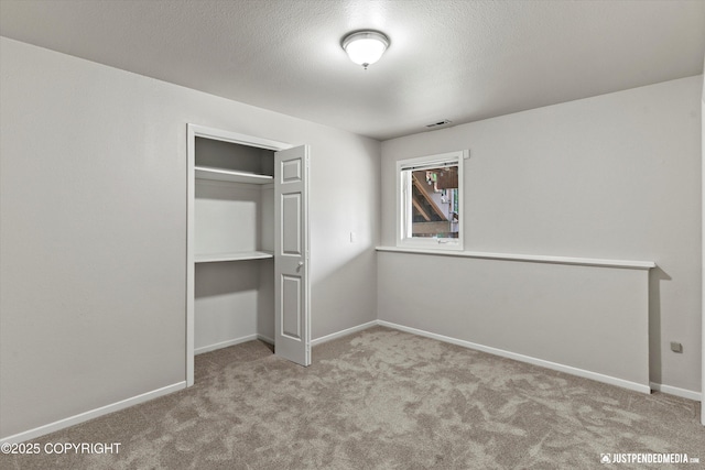 18704 Snowy Plover Cir, Anchorage, AK 99516 - unfurnished bedroom featuring carpet flooring, a closet, baseboards, and a textured ceiling