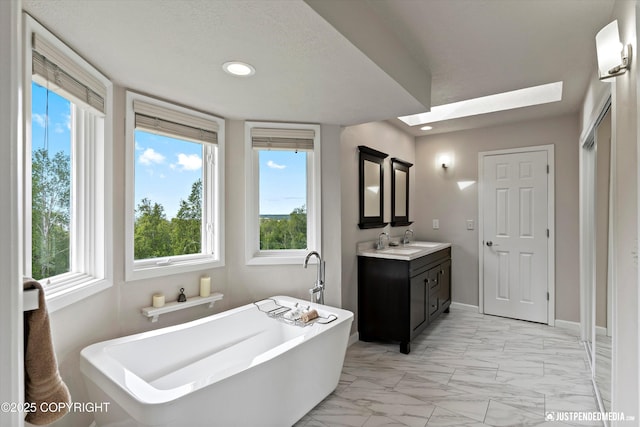 18704 Snowy Plover Cir, Anchorage, AK 99516 - full bathroom featuring marble look tile flooring, a freestanding bath, vanity, plenty of natural light, and recessed lighting