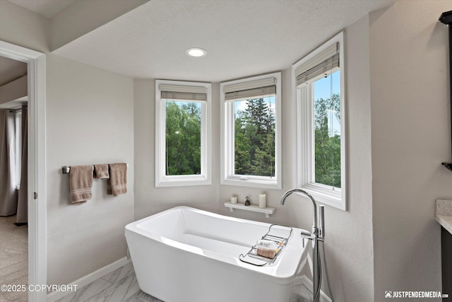 18704 Snowy Plover Cir, Anchorage, AK 99516 - full bath featuring a freestanding tub, baseboards, marble look tile flooring, and a textured ceiling