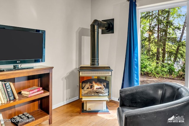 6840 Queens View Cir, Anchorage, AK 99504 - living area featuring a wood stove, baseboards, and wood finished floors